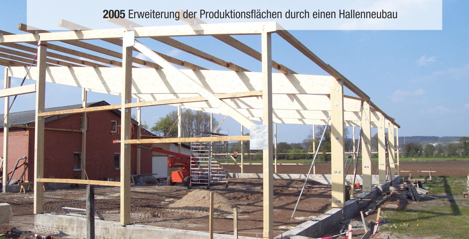Bauger&uuml;st f&uuml;r einen Hallenneubau mit Holzstruktur und angrenzender Lagerfl&auml;che; im Hintergrund eine Ebene.