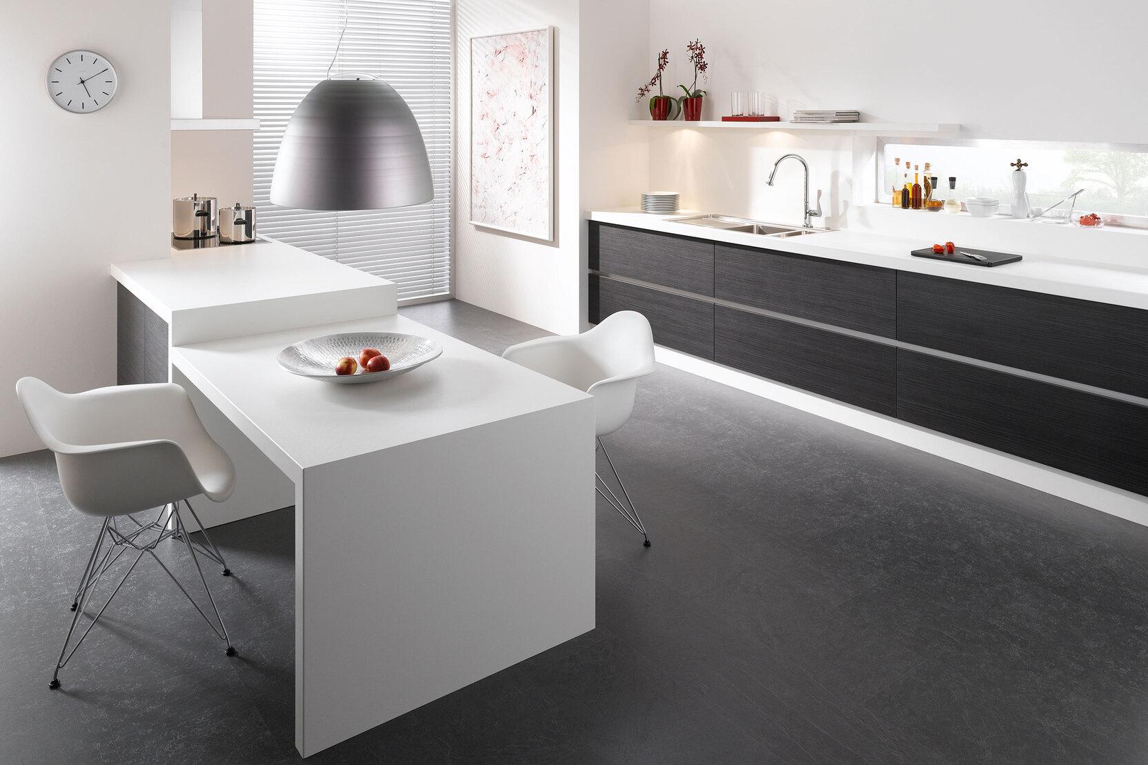 Impression einer einzeiligen Küchengestaltung in schwarz-weiß mit Esstisch für Zwei