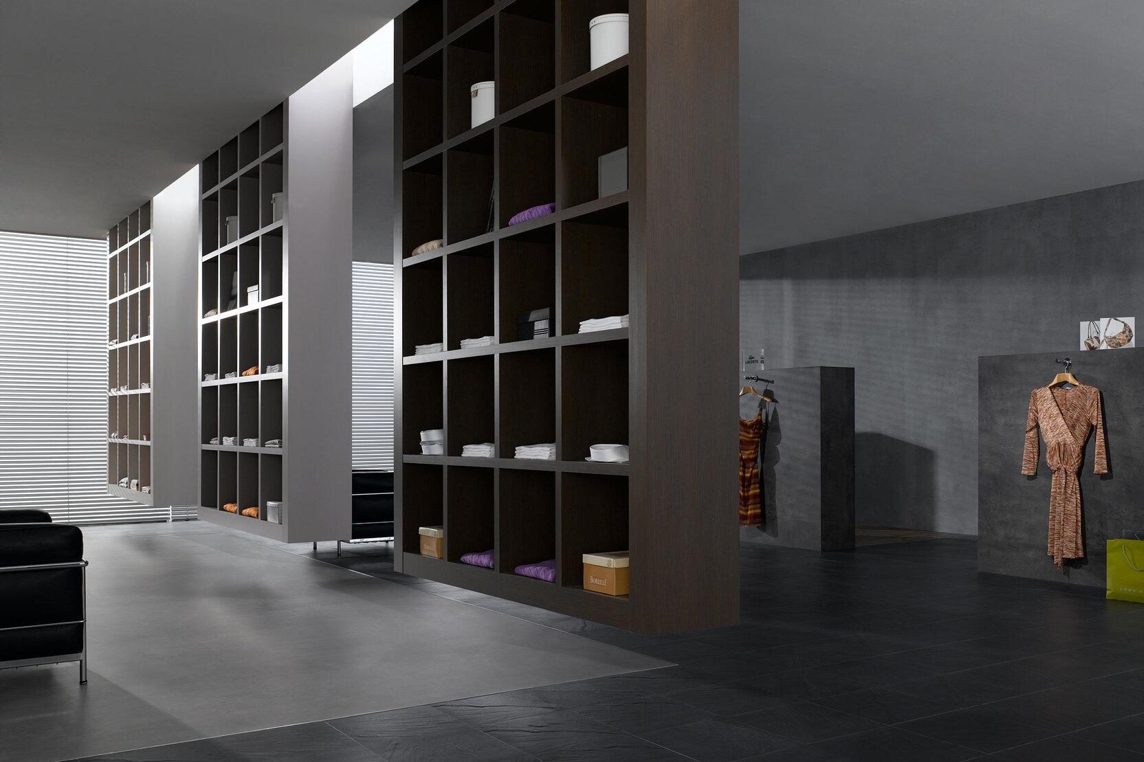 Impression eines geräumigen Regalsystems aus dunklem Holz in einem hochwertigen Bekleidungsladen