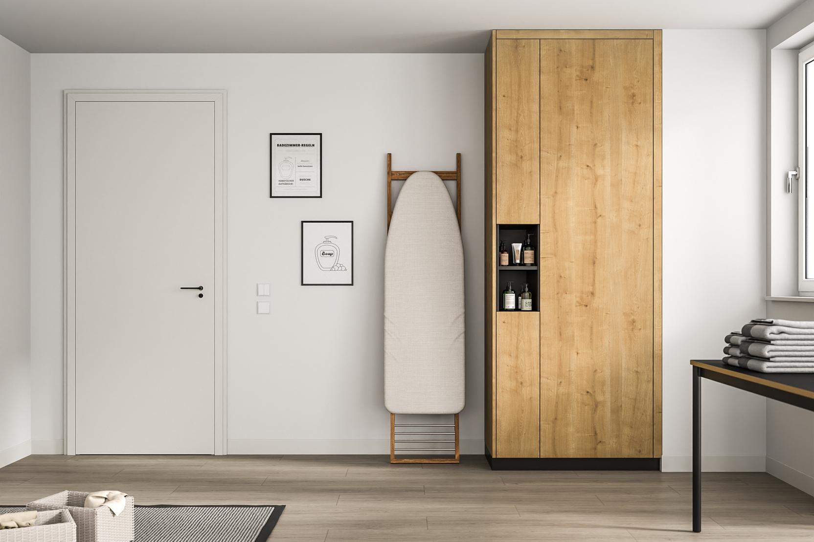 Moderner, maßangefertigter Holzschrank in minimalistischem Raum. Ein hoher, maßgeschneiderter Holzschrank in natürlicher Maserung steht neben einem Bügelbrett, gegenüber einer weißen Tür und minimalistischer Wandkunst.